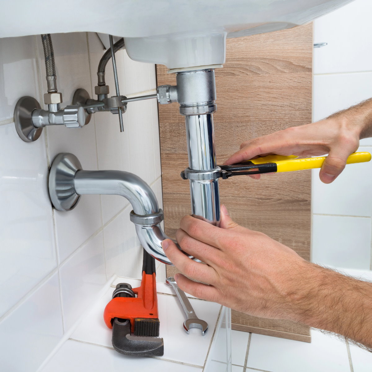 Das Bild zeigt Hände die ein Abfluss reparieren